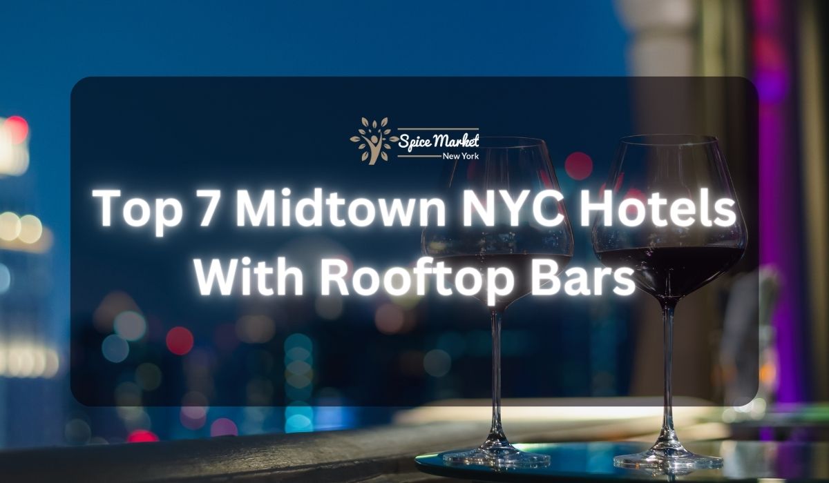 Top 7 Midtown NYC Hotels With Rooftop Bars - a rooftop bar with a table and 2 glasses of wine and a beautiful city lights view