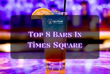 Top 8 Bars In Times Square NYC - a nice glass of cocktail with ice and lemon on top placed on a table inside a bar