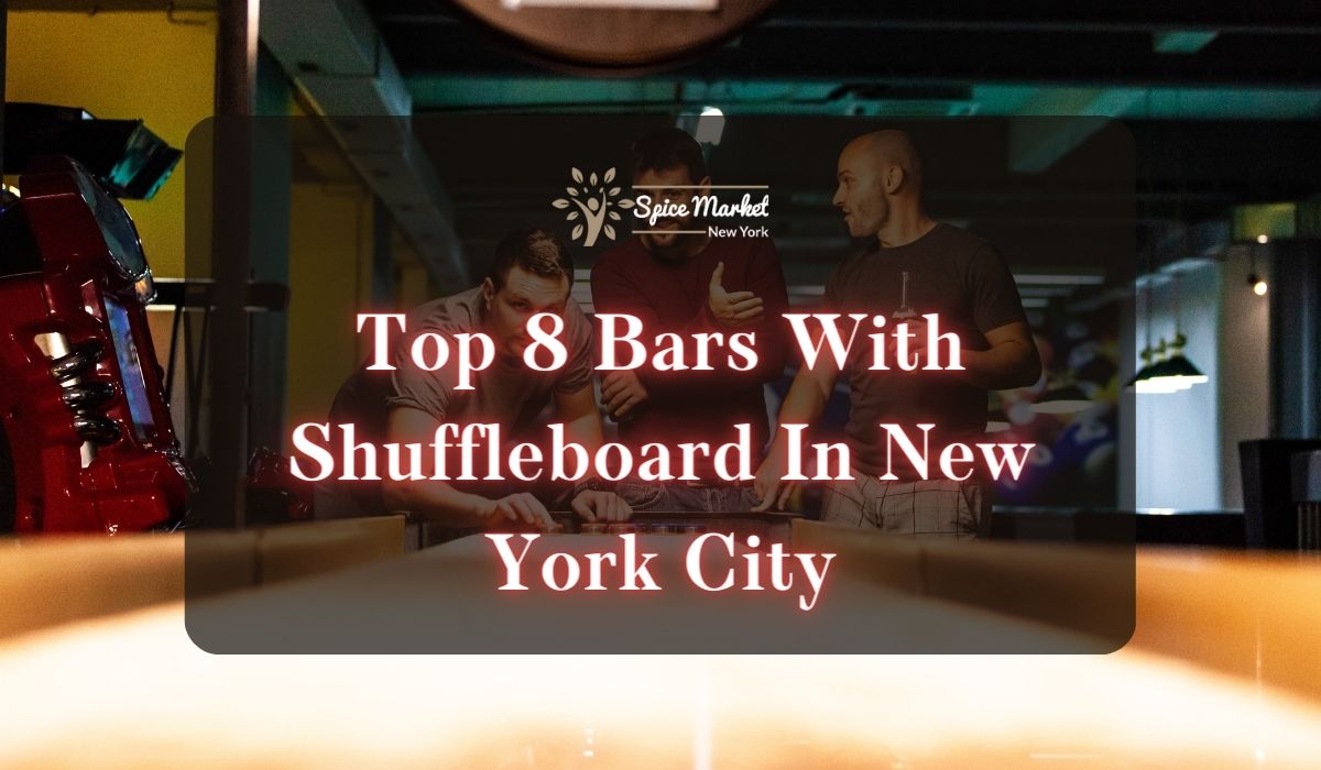 Top 8 Bars With Shuffleboard In New York City - three men playing with a shuffleboard while holding drinks at a bar